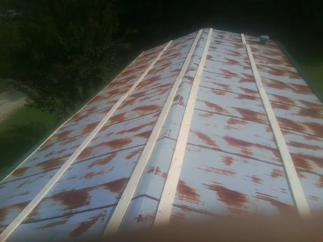 Rusted metal roof panels with new wood purlins before replacement — Storm Damage Roof Repair in Weyers Cave by Roofing Brothers