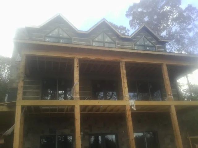 Dormers and porch framing on a large log home under construction — Roof Coating work by our crew in Weyers Cave