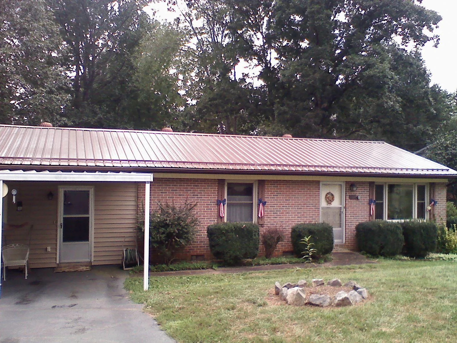 Bronze metal roof and carport on a brick ranch home — Roof Repair work by our crew in Weyers Cave
